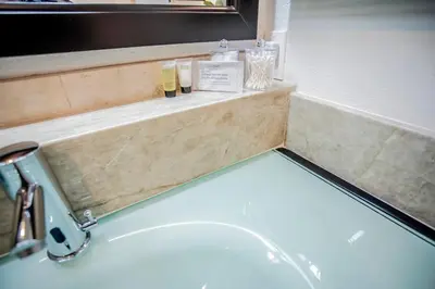 a bathroom sink with two bottles of soap and a mirror at Buena Creek Vista Primary Subdivided Home with Views and Pool in San Marcos