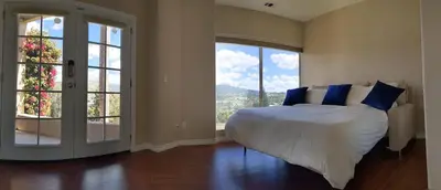 a bedroom with a large bed with blue pillows at Buena Creek Vista Primary Subdivided Home with Views and Pool in San Marcos