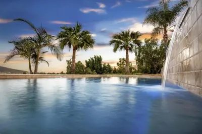 a swimming pool with a fountain and palm trees at Buena Creek Vista Primary Subdivided Home with Views and Pool in San Marcos