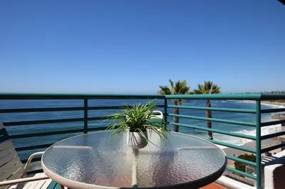 a table with a plant on a balcony with the ocean at Laguna Surf in Laguna Beach