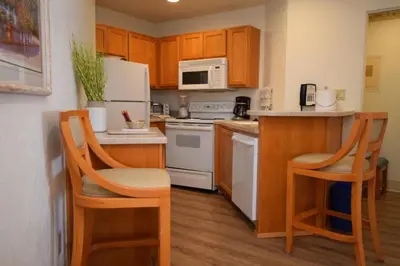 a kitchen with white appliances and wooden cabinets at Laguna Surf in Laguna Beach