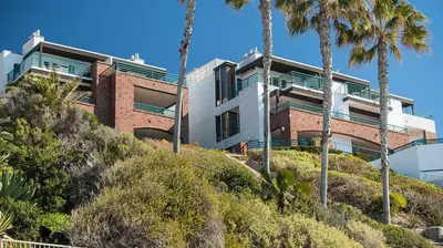 a building on a hill with palm trees at Laguna Surf in Laguna Beach