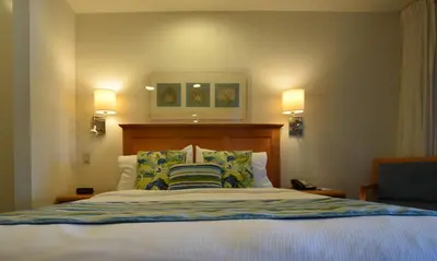 a bedroom with a bed with two pillows and two lights at Laguna Surf in Laguna Beach