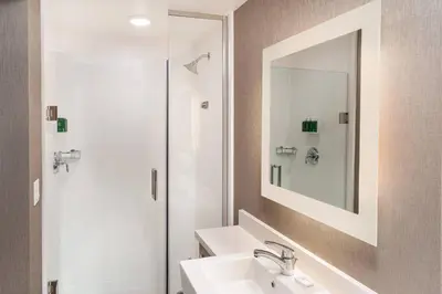 a bathroom with a sink and a shower with a mirror at SpringHill Suites by Marriott Irvine Lake Forest in Lake Forest