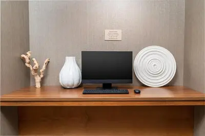 a desk with a computer monitor and a vase at SpringHill Suites by Marriott Irvine Lake Forest in Lake Forest