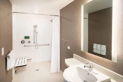 a white bathroom with a sink and a shower at SpringHill Suites by Marriott Irvine Lake Forest in Lake Forest