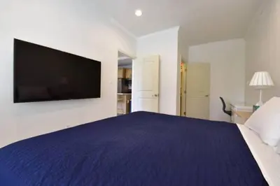 a bedroom with a large bed with a tv on the wall at 1000#2 Magnificent Beach Home w/ AC & 4K TVs in Newport Beach