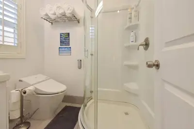 a bathroom with a toilet and a glass shower at 1000#3 Renovated Home by Beach & Sand - AC & More! in Newport Beach