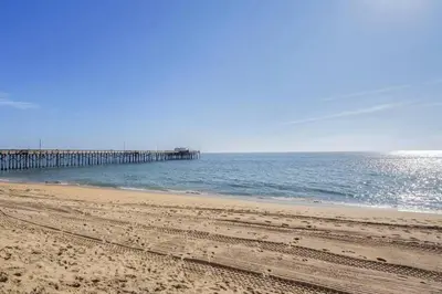 a view of a beach with a pier in the water at 1000#4 Modern Beach Home, Steps from Sand w/AC! in Newport Beach