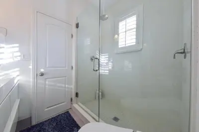 a white bathroom with a shower and a toilet at 1000#5 Premier Modern Home w View, Parking, and AC in Newport Beach