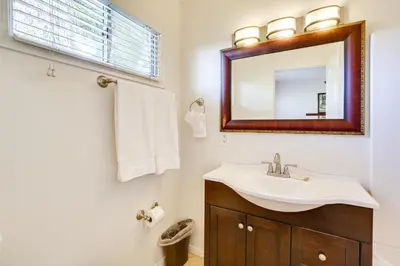 a bathroom with a sink and a mirror at Tropical Oceanside Home with Deck, Walk to Beach in Oceanside