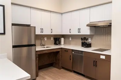 a kitchen with white cabinets and a stainless steel refrigerator at Staybridge Suites - Temecula - Wine Country by IHG in Temecula