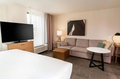 a hotel room with a couch and a flat screen tv at Staybridge Suites - Temecula - Wine Country by IHG in Temecula