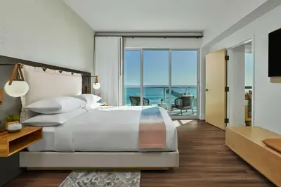 a bedroom with a bed and a view of the ocean at Mission Pacific Beach Resort, part of JdV by Hyatt in Oceanside