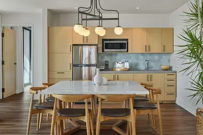 a kitchen with a white table and chairs at Mission Pacific Beach Resort, part of JdV by Hyatt in Oceanside