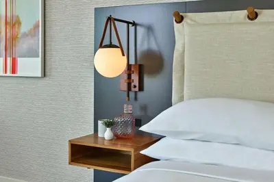 a bedroom with a bed and a table with a lamp at Mission Pacific Beach Resort, part of JdV by Hyatt in Oceanside