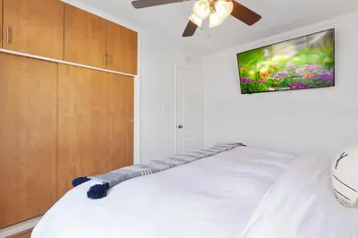 a bedroom with a bed with a tv on the wall at Victoria #5 in San Clemente