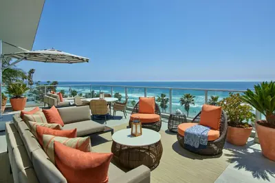 a patio with furniture and the ocean in the background at The Seabird Ocean Resort & Spa, Part of Destination Hotel by Hyatt in Oceanside