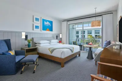 a bedroom with a bed and a living room at The Seabird Ocean Resort & Spa, Part of Destination Hotel by Hyatt in Oceanside