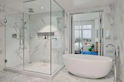 a white bathroom with a tub and a glass shower at The Seabird Ocean Resort & Spa, Part of Destination Hotel by Hyatt in Oceanside