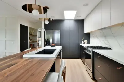 a kitchen with black and white cabinets and a wooden floor at Luxury Cardiff by-the-Sea Ocean View Penthouse in Encinitas