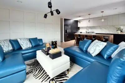 a living room with blue couches and a kitchen at Luxury Cardiff by-the-Sea Ocean View Penthouse in Encinitas