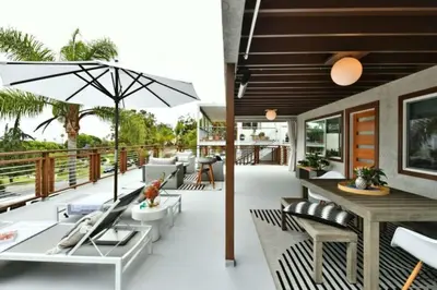 an outdoor patio with a table and chairs and an umbrella at Luxury Cardiff by-the-Sea Ocean View Parkhouse in Cardiff-by-the-Sea