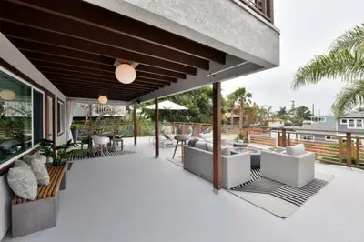 an outdoor patio with couches and tables on a building at Luxury Cardiff by-the-Sea Ocean View Parkhouse in Cardiff-by-the-Sea