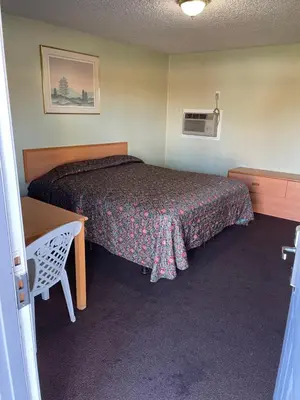 a hotel room with a bed and a table and a desk at RAMONA MOTEL in Hemet