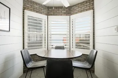 a table and chairs in a room with windows at The Marbella in Oceanside