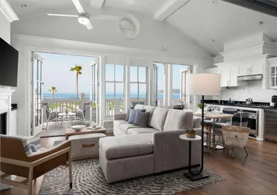 a living room with a couch and a kitchen with the ocean at Beach Village at The Del, LXR Hotels & Resorts in San Diego