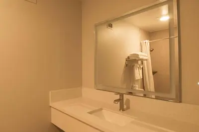 a bathroom with a sink and a large mirror at Days Inn by Wyndham Carlsbad in Carlsbad