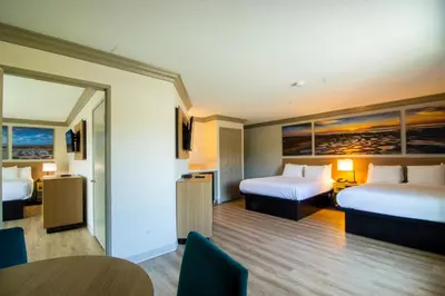 a hotel room with two beds and a table at Days Inn by Wyndham Carlsbad in Carlsbad