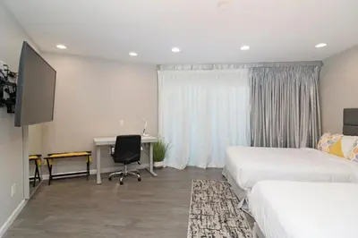 a hotel room with two beds and a desk and a computer at Sands Of La Jolla in San Diego