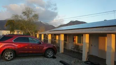 a red car parked in front of a building at Borrego Springs Motel in Borrego Springs
