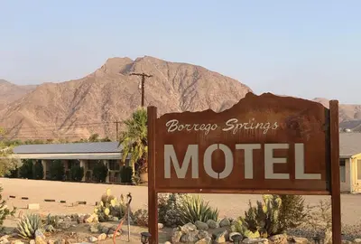 a sign for a motel in front of a mountain at Borrego Springs Motel in Borrego Springs