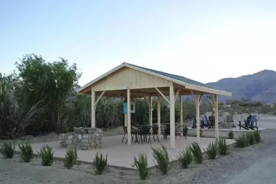 a gazebo with tables and chairs and mountains at Borrego Springs Motel in Borrego Springs
