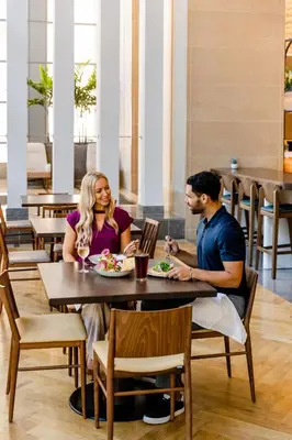 a man and woman sitting at a table in a restaurant at Omni San Diego Hotel at the Ballpark in San Diego