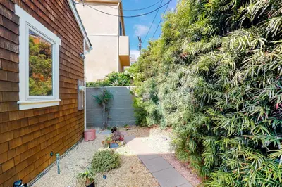 a garden next to a house with a wall at Sycamore Beach Retreat in Carlsbad
