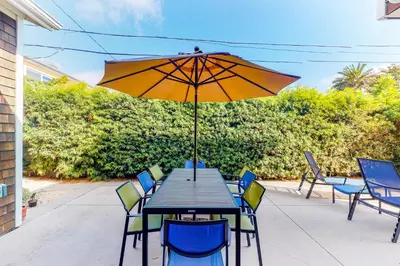 a table and chairs with an umbrella on a patio at Sycamore Beach Retreat in Carlsbad