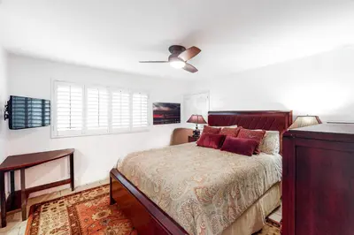 a bedroom with a bed and a ceiling fan at Luxury Oceanfront Home - Lower in Oceanside
