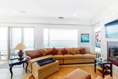 a living room with a couch and a tv at Luxury Oceanfront Home - Lower in Oceanside