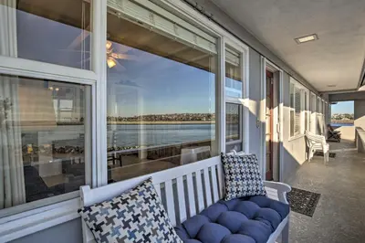 a porch with a blue couch and a large window at San Diego Hub with Bay Views - 1 Block to Beach! in San Diego