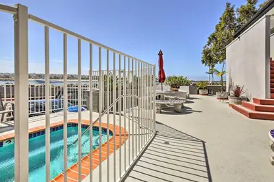 a swimming pool with a fence next to a building at San Diego Hub with Bay Views - 1 Block to Beach! in San Diego