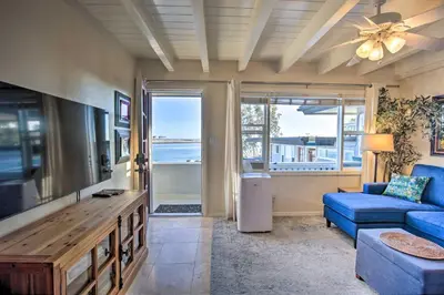 a living room with a blue couch and a tv at San Diego Hub with Bay Views - 1 Block to Beach! in San Diego
