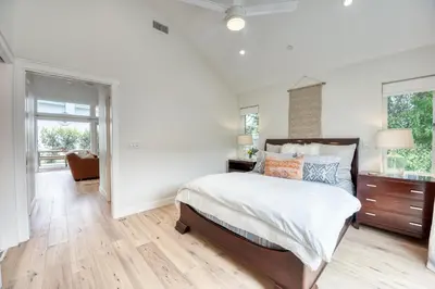 a white bedroom with a bed and a window at 727 Sonrisa St home in Solana Beach