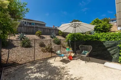a patio with two chairs and an umbrella at 727 Sonrisa St home in Solana Beach