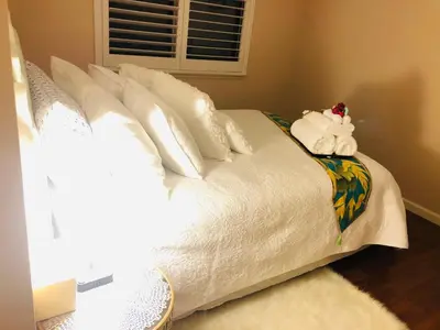 a white bed with white pillows and towels on it at Balloons and Wine in Murrieta
