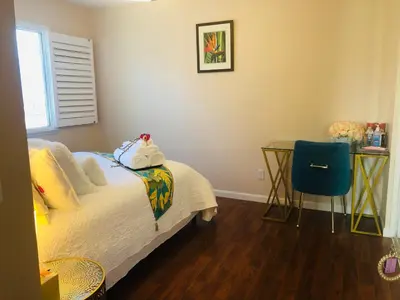 a bedroom with a bed and a table and a chair at Balloons and Wine in Murrieta