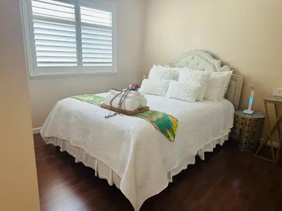 a bedroom with a bed with a white bedspread at Balloons and Wine in Murrieta